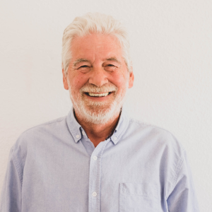 Older man shows off his healthy, confident smile after expert dental and cosmetic care at Arizona Smiles in Gilbert, AZ.